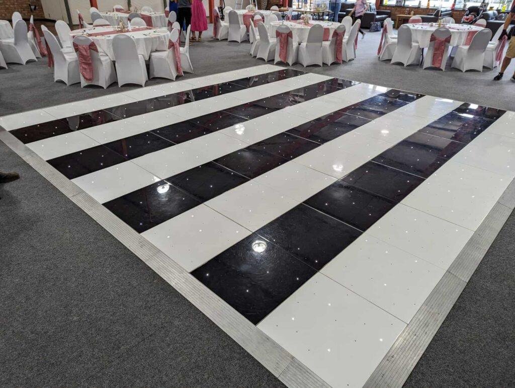 Starlight Wedding Package dance floor with glossy black and white tiles.
